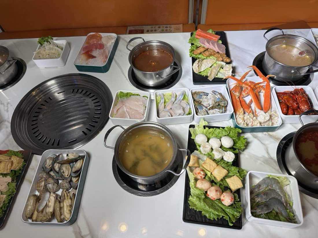 The Hot Lava Pot table A full table of hot pot broth, meats, seafood and vegetables ready to cook