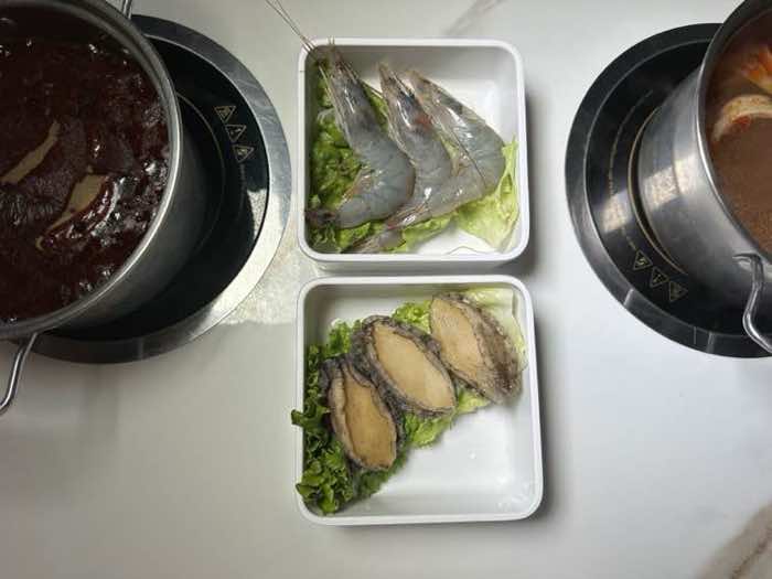 Fresh head-on prawns and abalone plated between a spicy red broth and a second simmering pot